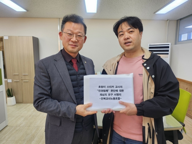 (오른쪽부터) 정재석 전북교사노조 위원장이 호랑이 스티커 교사의 인권침해 판단에 대한 재심의 요구 서명지를 전북교육인권센터에 전달하고 있다.(사진=전북교사노조)