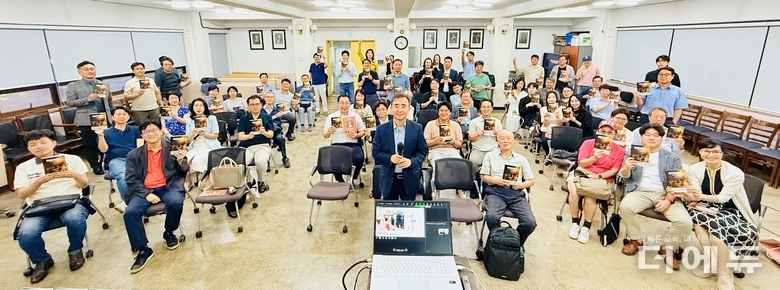 (가운데)임문영 미래전환 대표가 제334회 스마트포럼 강연을 마친 뒤 오프라인 참가자들과 그의 저서 '파레오로스'를 들고 기념 촬영을 하고 있다.(사진=여원동 기자)